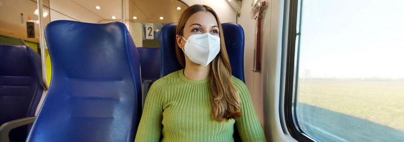 Banner of beautiful woman traveling on public transport wearing protective medical mask. 