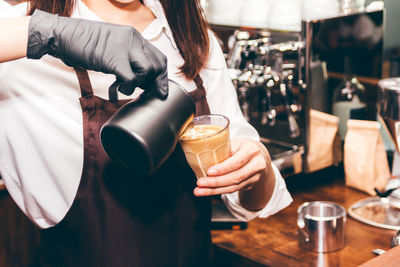 Midsection of woman holding coffee cup in restaurant