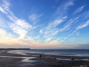 View of calm beach against blue sky