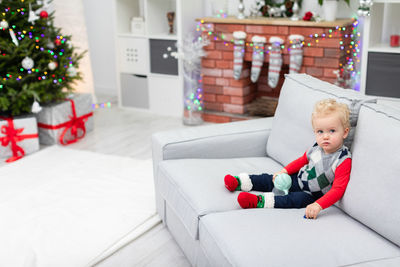 High angle view of boy playing with toy on sofa at home