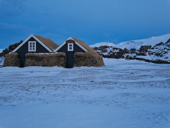 Built structure on snow covered landscape against sky