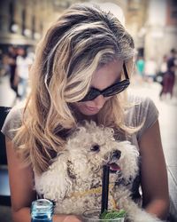 Young woman sitting with dog at outdoor cafe
