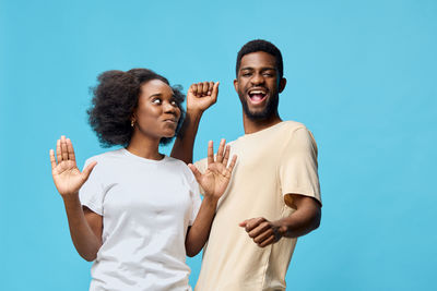 Portrait of smiling friends standing against blue background