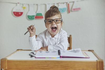 Charming child plays pretending to be a teacher