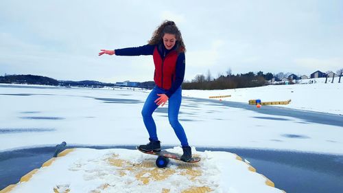 Full length of woman standing on frozen lake against sky