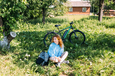 Portrait of woman sitting on grassy field