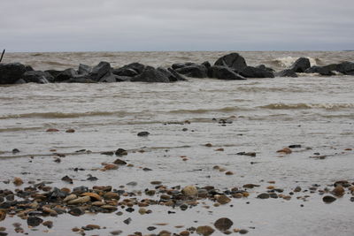 Rocks on beach against sky