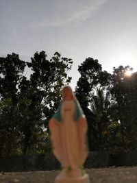 Rear view of woman standing by tree against sky