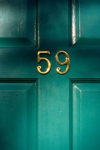 House number 59 on a turquoise wooden front door in london