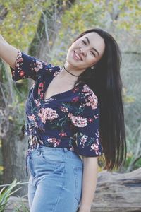 Beautiful young woman smiling while standing in park