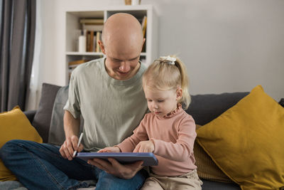 Side view of boy using digital tablet at home