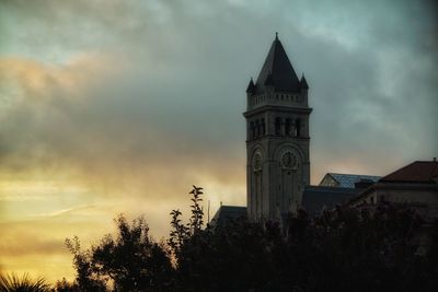 Low angle view of clock tower against cloudy sky