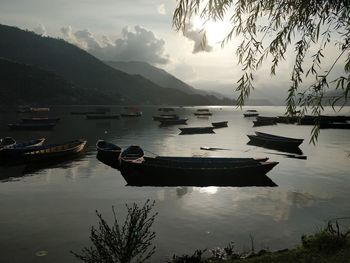 Boats moored in lake against sky