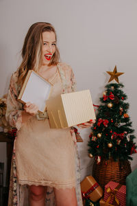 Woman holding christmas tree in box