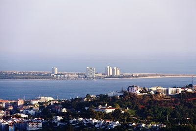 High angle view of city by sea against sky