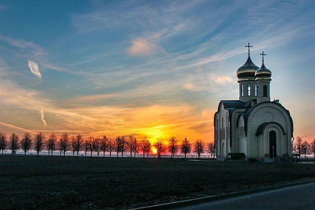 religion, church, place of worship, sunset, building exterior, sky, spirituality, architecture, built structure, cloud - sky, cross, orange color, cloud, cathedral, tree, outdoors, nature, beauty in nature