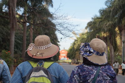 Rear view of people wearing hats on road