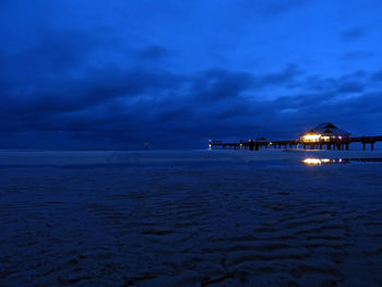 Pier on sea against cloudy sky