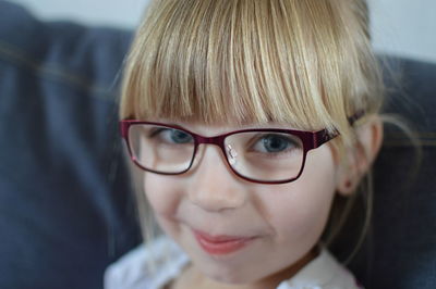Close-up portrait of cute smiling girl wearing eyeglasses