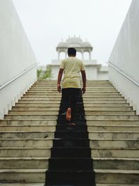 Rear view full length of man moving up on steps