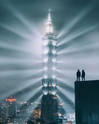 Low angle view of illuminated buildings against sky at night