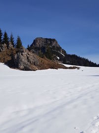 Scenic view of snowcapped mountains against clear blue sky