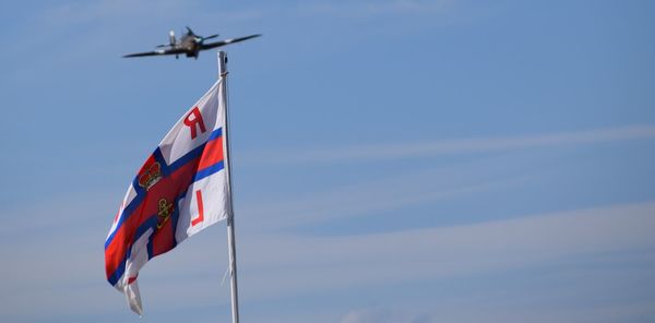 Low angle view of flag against blue sky