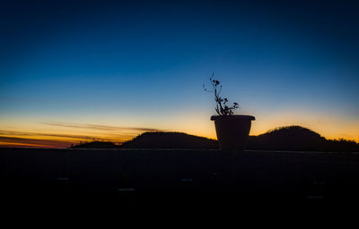 Silhouette windmill against sky at sunset