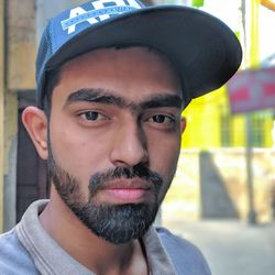 Close-up portrait of young man wearing cap