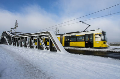 Cars on road against cloudy sky