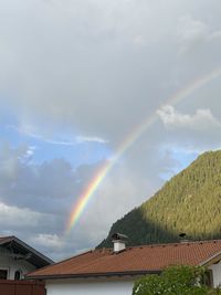 Low angle view of rainbow over buildings against sky
