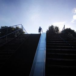 Low angle view of woman against blue sky