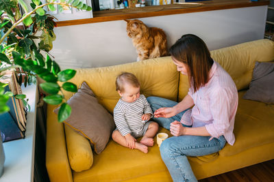 Mom feeds a small child at home with yogurt from a spoon. family concept