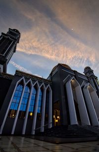 Low angle view of illuminated building against sky at sunset