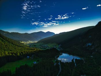 Scenic view of lake and mountains against blue sky