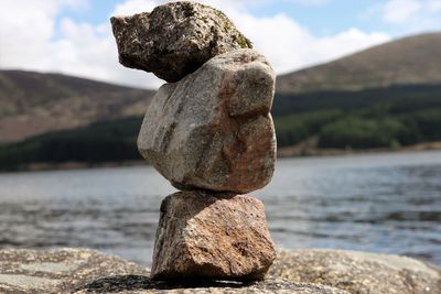 Close-up of stone stack on rock against sky