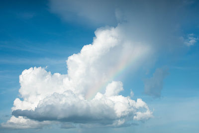 Low angle view of sunlight streaming through clouds