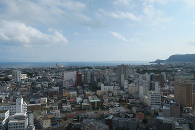 Aerial view of buildings in city against sky