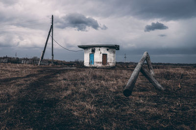 Abandoned building on field against sky