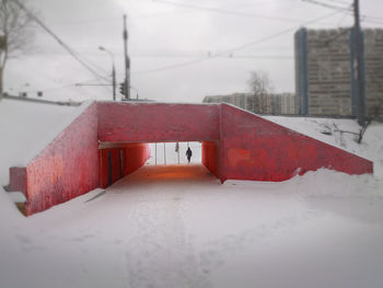 Red umbrella on snow covered landscape during rainy season