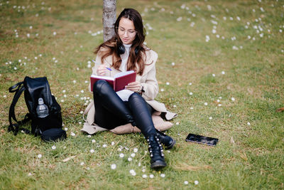 Young woman sitting on book