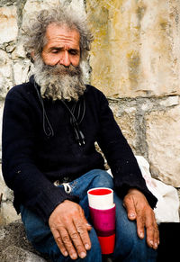 Portrait of man with coffee sitting outdoors