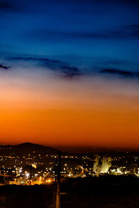 Illuminated cityscape against sky at night