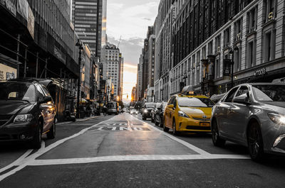 Cars on road in city against sky