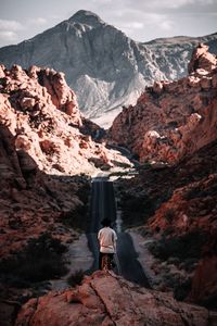 Rear view of person standing on rock