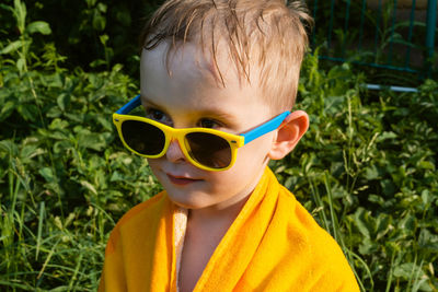 Wet and cheerful child in a towel and sunglasses. boy look away.summer is a time of pleasure and fun