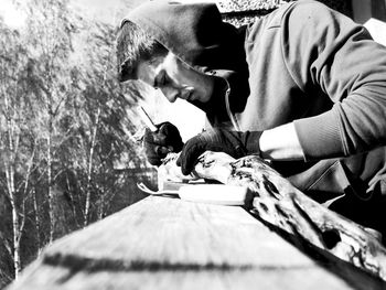 Side view of man carving wood