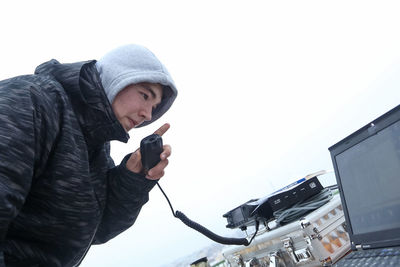 Full length of man holding snow against clear sky