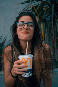 Portrait of young woman drinking drink