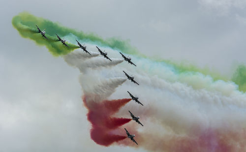 Low angle view of airplanes flying against sky